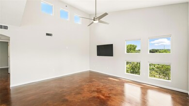 Spare room with a high ceiling, ceiling fan, conc