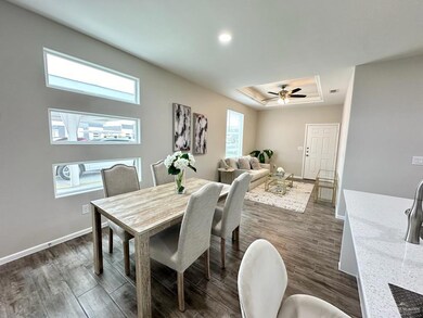 Dining space featuring a wealth of natural light, baseboards, a raised ceiling, and dark wood-type flooring