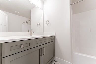 Bathroom featuring vanity, a textured ceiling, and shower / washtub combination