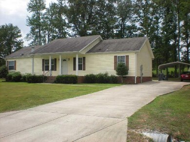 This well maintained home has an extended concrete drive and a  car carport