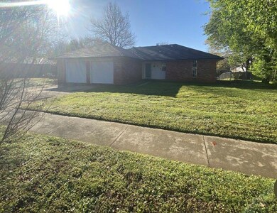 Ranch-style house with a front yard and a garage