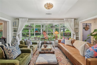 Living room featuring built in features and a large wall of windows allowing ample sunlight