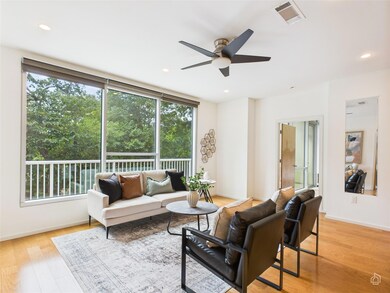 Living room with a ceiling fan, light wood finish