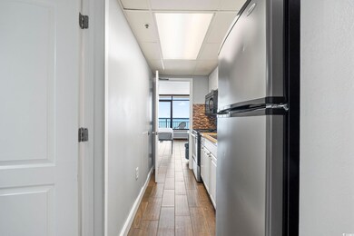 Kitchen featuring backsplash, white cabinetry, woo