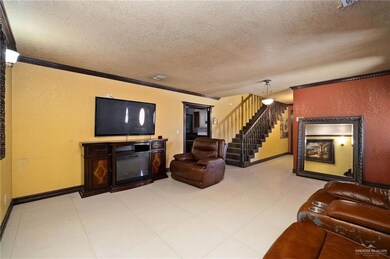 Living area with crown molding, a textured wall, a textured ceiling, and stairway