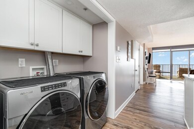 Washroom with cabinets, wood-type flooring, washin