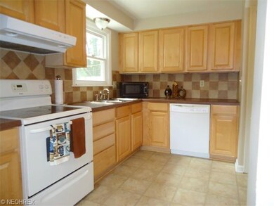 The kitchen features lovely maple cabinets, tile b