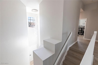 Stairs with wood finished floors and baseboards