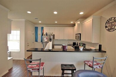 Kitchen featuring kitchen peninsula, white cabinet