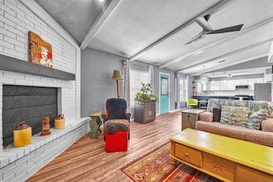 Living room with wood finished floors, a textured ceiling, and a fireplace