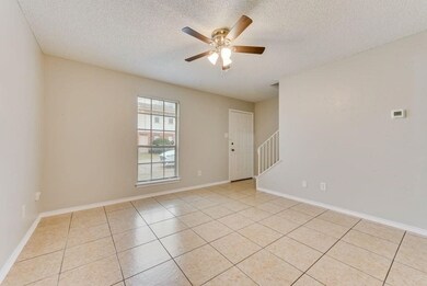 Unfurnished room featuring a textured ceiling, light tile patterned floors, and a ceiling fan