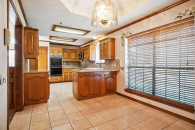 Kitchen with kitchen bar, a textured ceiling, ligh