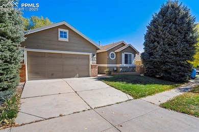 View of front of property with concrete driveway, a garage, a front lawn, and brick siding