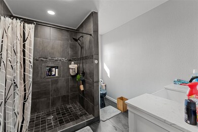 Bathroom featuring sink, toilet, and a shower with