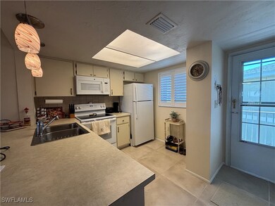 Kitchen with tasteful backsplash, a sink, white ap