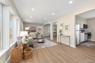 Living room with light wood finished floors and recessed lighting