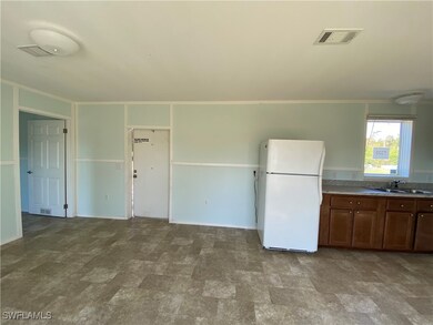 Kitchen featuring white refrigerator, ornamental molding, and sink