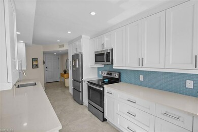 Kitchen featuring appliances with stainless steel finishes, white cabinets, recessed lighting, light stone counters, and decorative backsplash