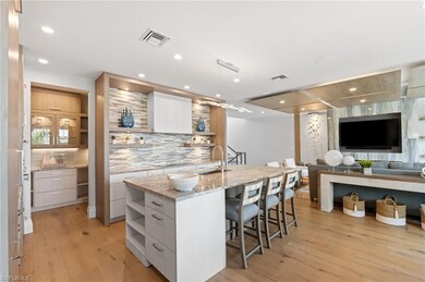 Kitchen featuring open shelves, modern cabinets, a sink, a breakfast bar area, and recessed lighting