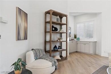 Sitting room featuring baseboards and light wood-t