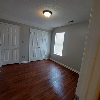 Unfurnished bedroom with a textured ceiling and da