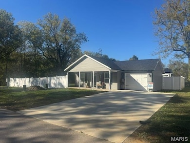 Ranch-style house with an attached garage, concrete driveway, and covered porch