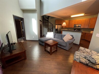 Living room with stairs, dark wood-style floors, 