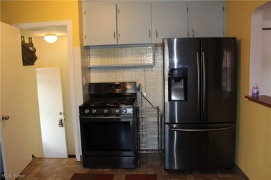 Kitchen featuring  fridge with ice dispenser, gas range oven, tasteful backsplash, and vinyl flooring