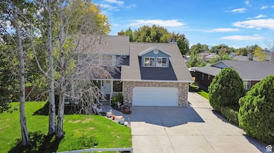 Traditional-style home featuring driveway, a shingled roof, a front yard, a garage, and brick siding