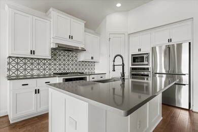 Kitchen featuring ventilation hood, a sink, backs
