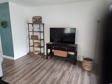 Living room with baseboards and wood finished floo
