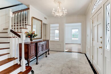 Enter the front door, and the marble foyer accesses the dining room to the right (pictured) and living room to the left (not shown in this photo).