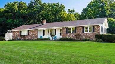 Ranch-style house with a storage unit and a front lawn