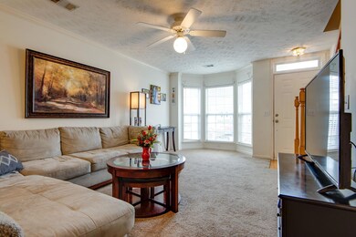 Living room from another angle (with furniture and old carpet).   Bay window
