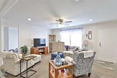 Carpeted living room with ceiling fan