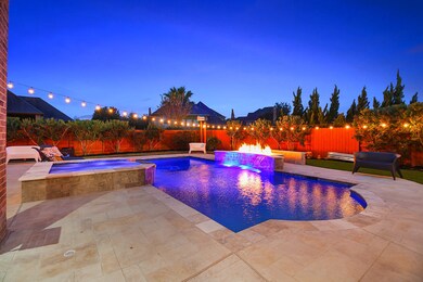 Large pool with a stunning waterfall below the fire wall. This home was made for entertainers! SPACE AND STUNNING features throughout!