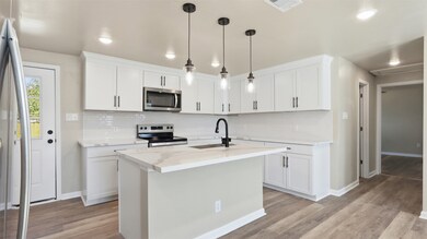 View from the kitchen looking into the bright and open living space, highlighting the stunning natural light and elegant quartz countertops.
