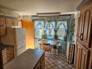 Kitchen with light brown cabinetry, radiator, and 