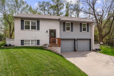 Split foyer home with a front yard and a garage