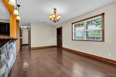 Unfurnished living room with baseboards, a chandel
