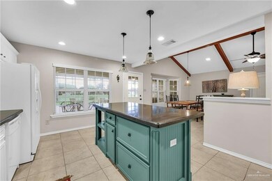 Kitchen featuring green cabinetry, dark countertops, light tile patterned floors, and recessed lighting