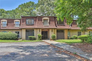 Townhome / multi-family property featuring mansard roof, roof with shingles, and stucco siding