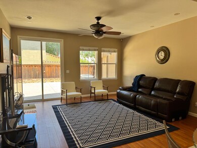 Bright and airy family room featuring wood finished floors and a ceiling fan