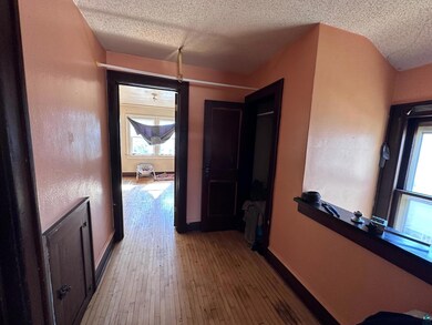 Hall featuring light wood-style flooring, baseboar