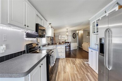 Kitchen has laminate wood flooring, neutral paint
