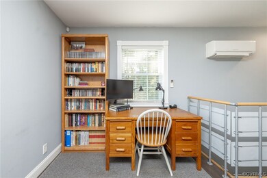 Carpeted home office with a wall mounted air condi