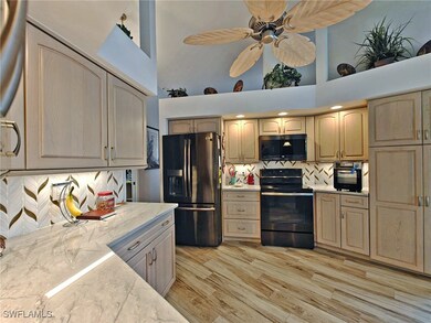 Kitchen with light wood finished floors, backsplas
