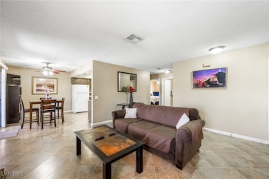 Living area featuring a textured ceiling and ceiling fan