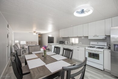 Dining area with light wood-style floors, ceiling fan, and a textured ceiling