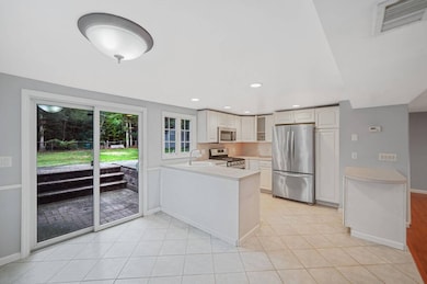 Kitchen with appliances with stainless steel finishes, a peninsula, light countertops, light tile patterned floors, and recessed lighting